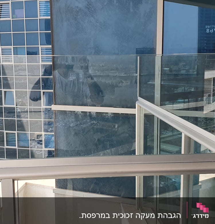 מעקה זכוכית במרפסת עם השתקפות בניינים